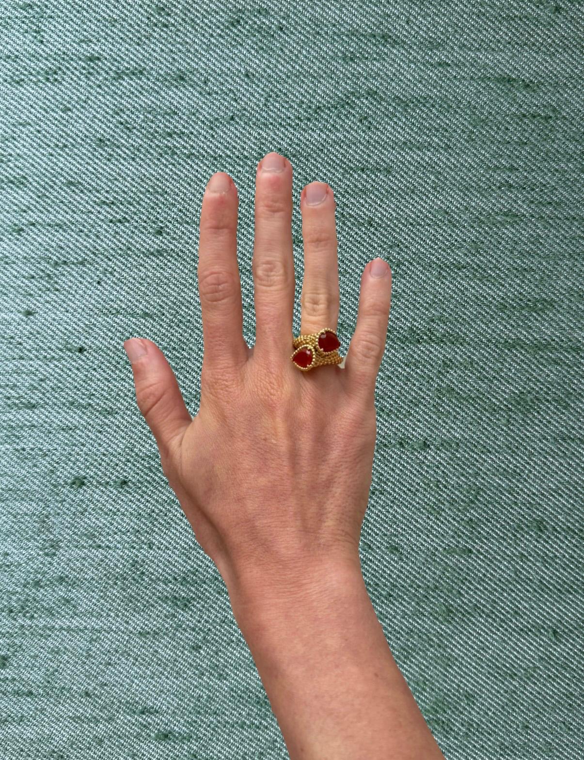 Boucheron ring with red cabochon stones worn on a hand